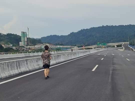 Seorang wanita kelihatan sedang berjogging di Lebuh Raya Bertingkat Sungai Besi-Ulu Kelang (SUKE) yang masih dalam pembinaan. - Foto ihsan Facebook/Brainless Driver Malaysia Edition