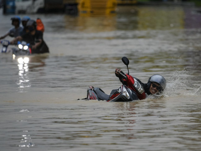 Seorang penunggang motosikal terjatuh ketika meredah banjir di Selangor. - Foto ihsan Bernama